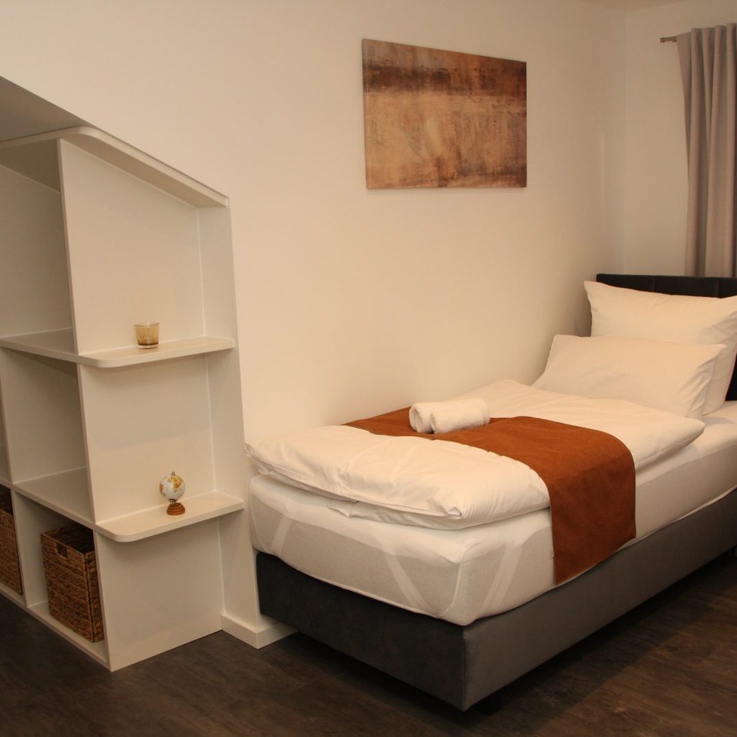 Schlafzimmer 2 mit Blick auf das eingebaute Regal für zusätzlichen Stauraum