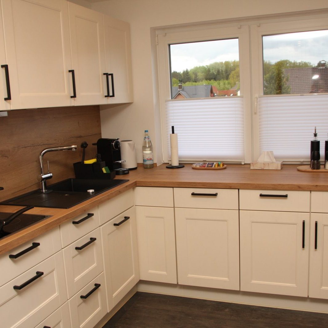 Küchenansicht mit vollausgestatteter Einbauküche in hellen Tönen, Apartment Augustdorf“