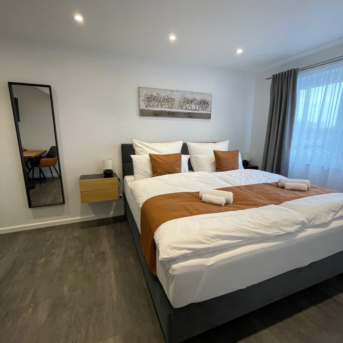 Frontansicht des Bettes im Schlafzimmer 1, mit geschmackvoller Bettwäsche und angenehmer Atmosphäre