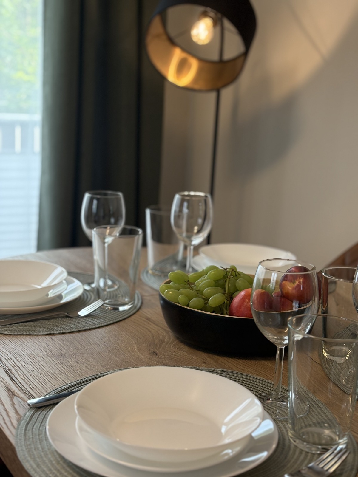 schön gedeckter Esstisch mit weißen Tellern, Wasser- und Weingläsern